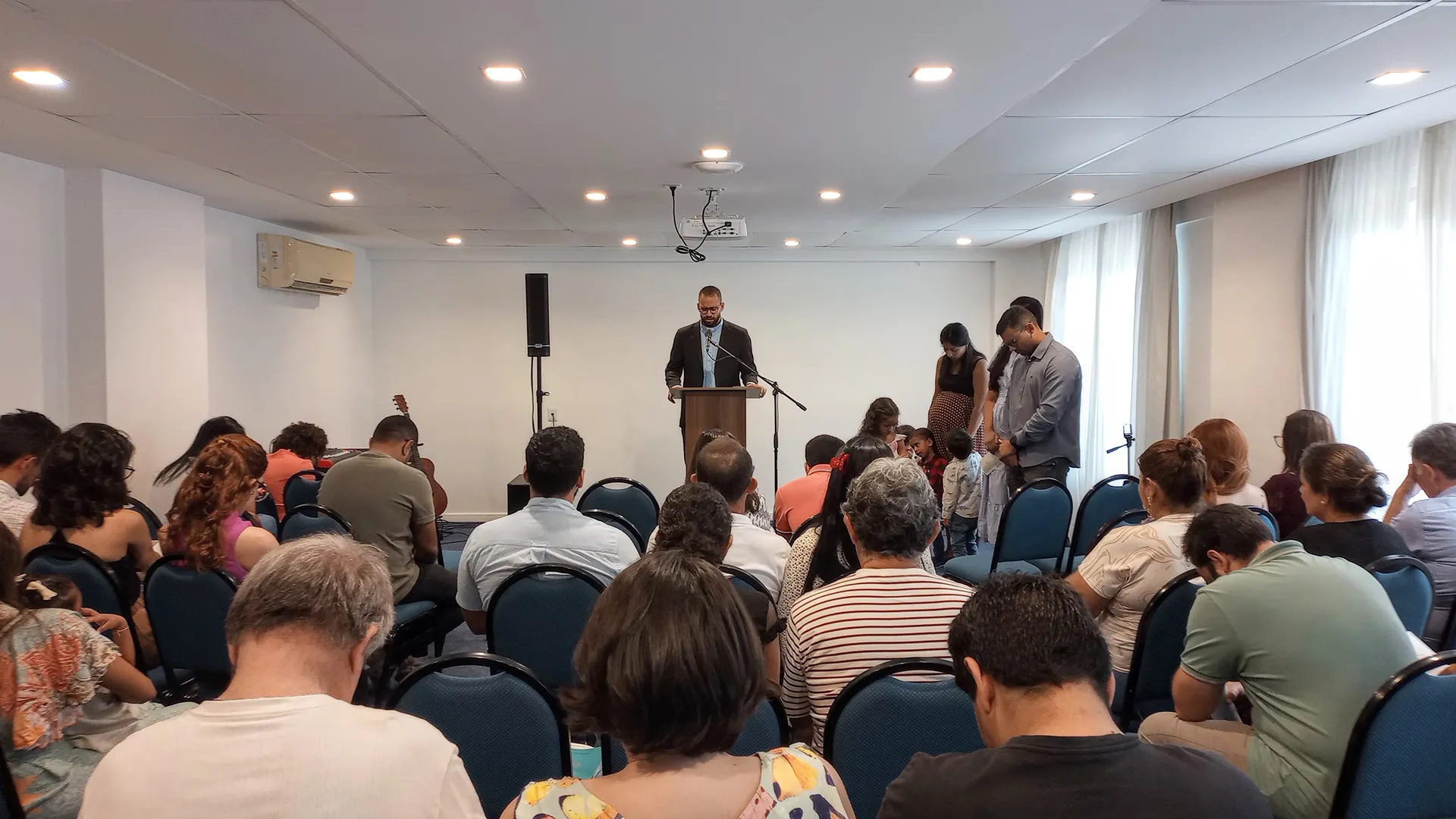 Congregação reunida em oração durante culto da Igreja Batista Redenção